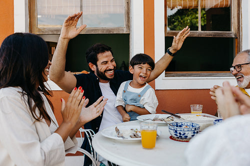 Family enjoying a lively gathering outdoors with food and laughter