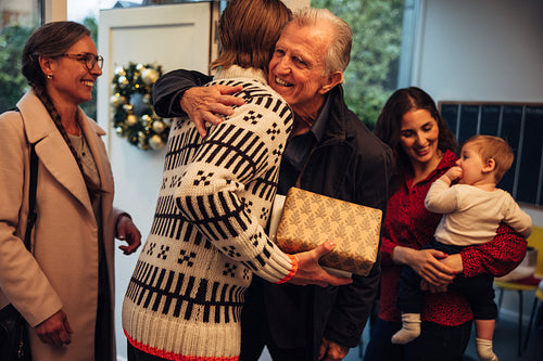 Man welcoming family at doorway