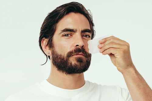 Skincare with a gua sha stone: Man massages his face with the beauty tool