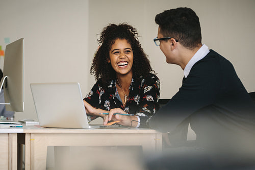 Smiling businesswoman discussing work with colleague in office