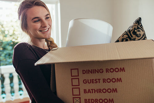 Woman carrying household stuff in a packing box