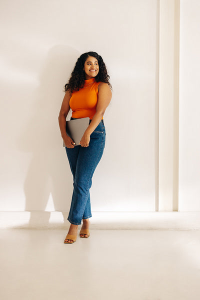 Successful businesswoman standing against an office wall