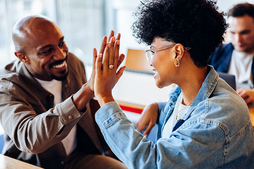 Celebrating the win: Coworkers high-fiving after a business success