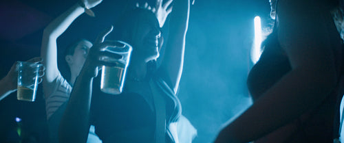 Friends dancing at night on a smoky dance floor