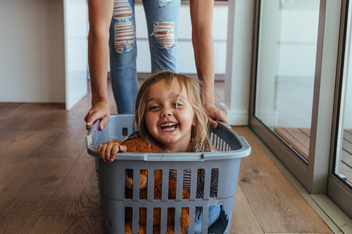 Little girl and her mother having fun doing laundry