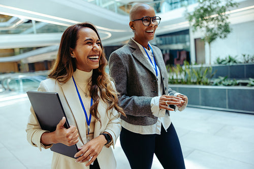 Two female professionals walking in modern corporate setting