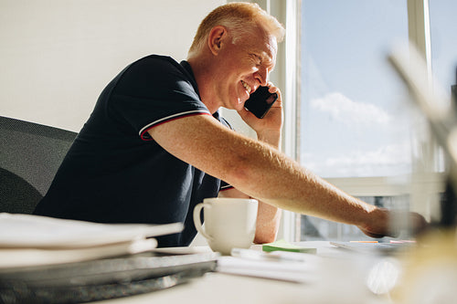 Senior businessman having a phone call at his desk