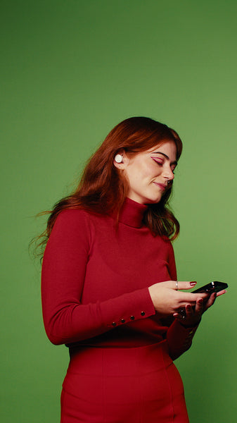 Happy woman in red dress enjoying music on green screen background