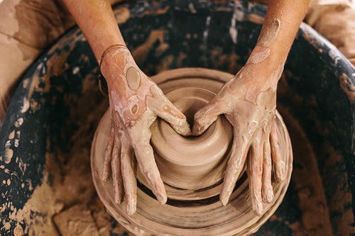 Potter moulding clay on pottery wheel