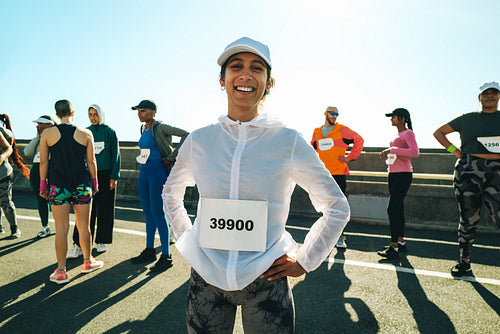 Confident female runner smiling before a marathon race
