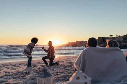 Man proposing to his girlfriend at sea shore