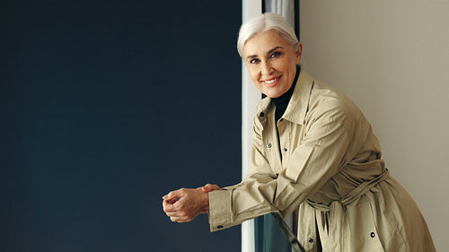 Mature female professional standing on balcony inside her office