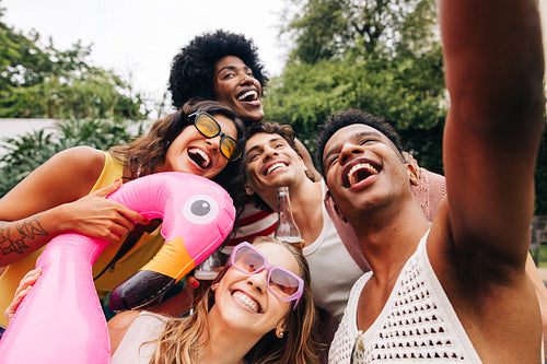 Friends take a carefree selfie at a sunny party