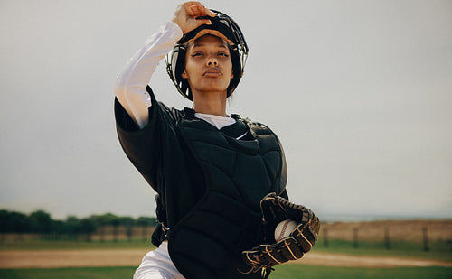 Confident baseball catcher in full gear stands ready on the field with mitt in hand
