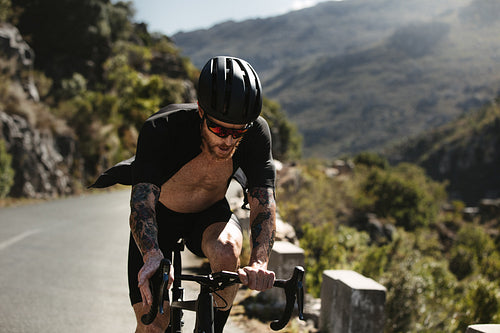 Fit cyclist doing uphill bicycle ride