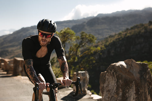 Racer riding a bicycle on mountain road