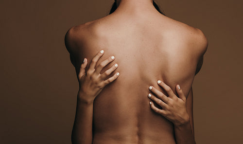 Sensual couple hugging on brown background