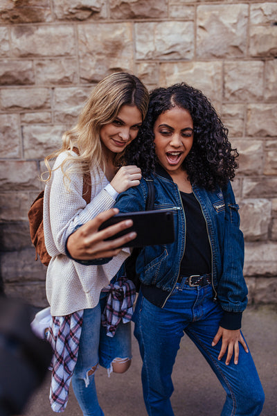 Two women posing for a selfie outdoors