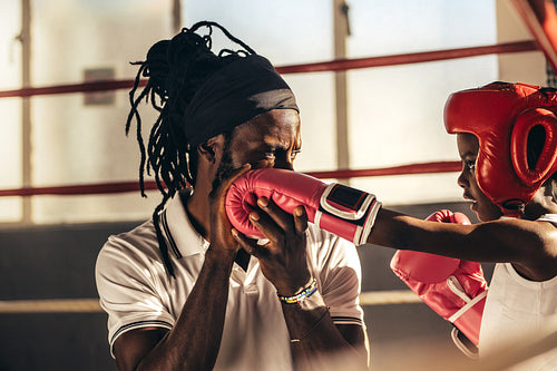 Boxing coach teaching a kid how to punch