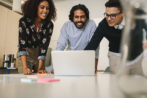 Business colleagues discussing work looking at a laptop