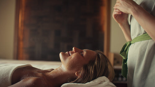 A woman enjoys a deeply relaxing spa treatment and a rejuvenating facial massage