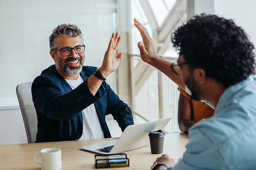 Successful business collaboration between two professional male colleagues in a startup office