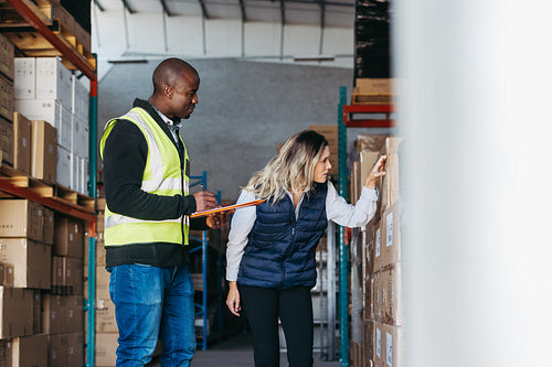 Two warehouse employees taking inventory