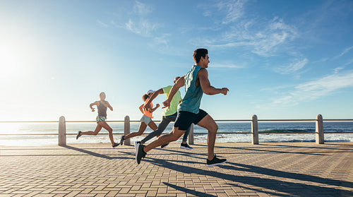 Young runners sprinting on the ocean front path