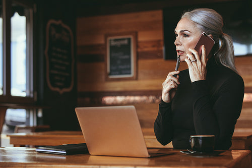 Senior business woman working from cafe