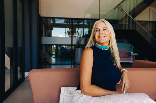 Confident woman sitting in a modern office with a bright smile