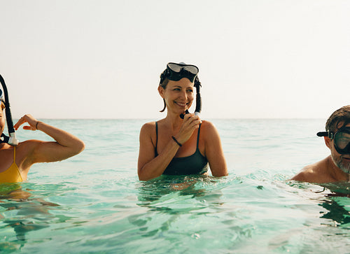 People snorkelling together in a bright tropical ocean