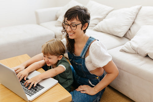 Woman and her son at home using a laptop