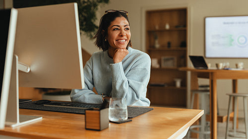 Woman works at a computer desk in the office for a business portrait