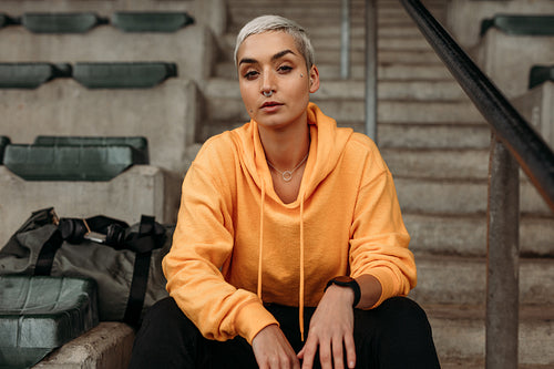 Fitness woman sitting on stairs in the stands of a stadium