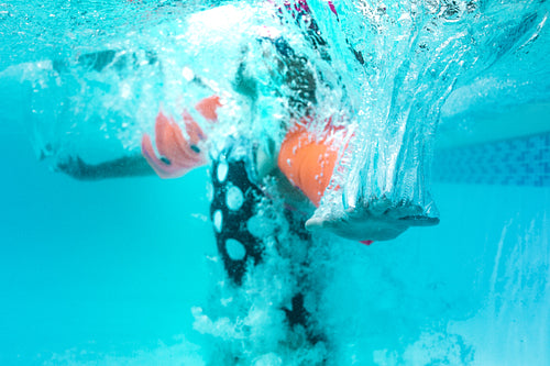 Girl child learning to swim in a pool