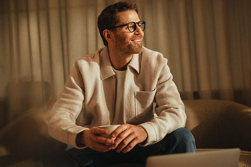 Businessman sits smiling in a modern office workspace