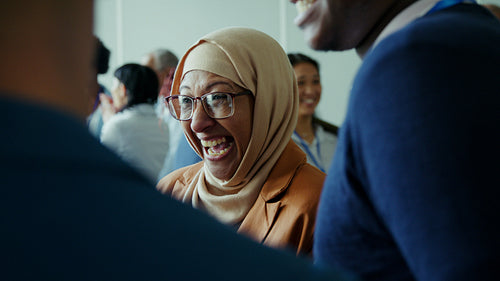 Diverse business professionals engaging and smiling at a corporate conference event