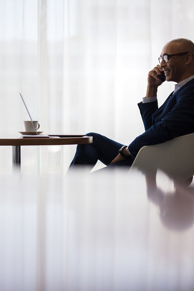 Businessman at office cafeteria and using phone