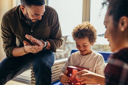 Parents giving a gift to their kid at a beach house