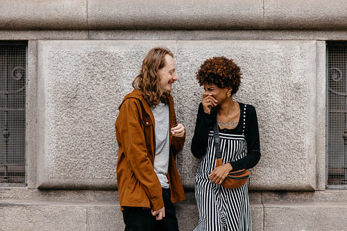 Affectionate couple sharing a laugh during an urban stroll