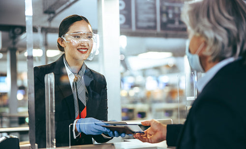 Flight attendant assisting passenger at check in counter
