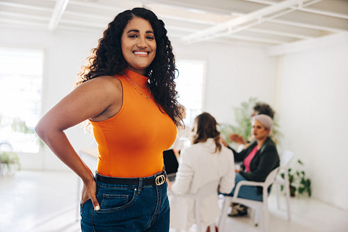 Cheerful young businesswoman standing in an all-female office