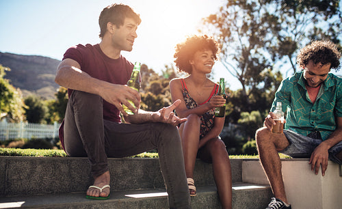 Young people having beers outdoors