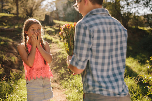 Boy giving a bunch of flowers to his girlfriend