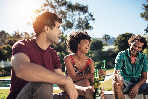 Young friends hanging out in backyard with beers