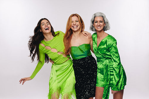 Three women laughing and hugging in studio
