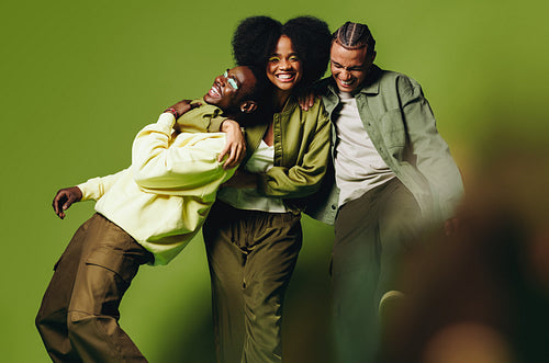 Joyful friends laughing together in a cheerful studio portrait
