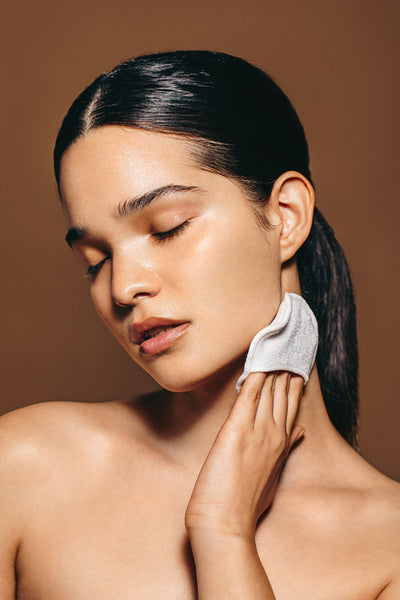 Effortless beauty routine: Woman gently massages her neck with a facial scrubber in an exfoliation process