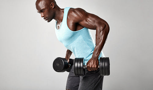 Healthy african man exercising with dumbbells