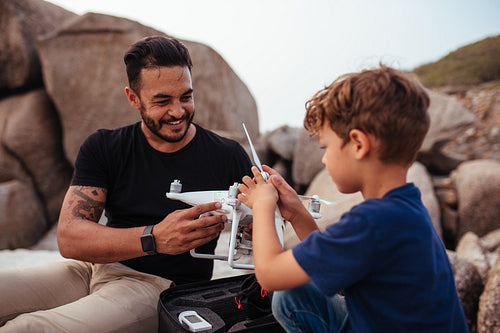 Father and son set up drone at the beach